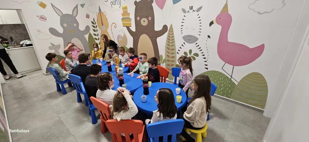 Djeca sjede za stolom i piju sok